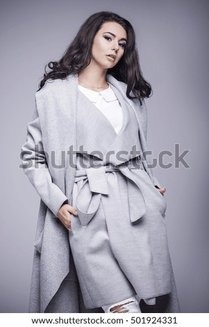 Beautiful young woman in an elegant gray coat