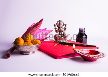 An auspicious Indian writing Shubha Labh means Goodness & Wealth, over Red accounting note book / bahi khata with goddess Laxmi idol, diya, sweets, lotus, pen with ink on Laxmi pujan, Diwali Festival Royalty-Free Stock Photo #501960661