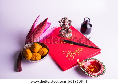 An auspicious Indian writing Shubha Labh means Goodness & Wealth, over Red accounting note book / bahi khata with goddess Laxmi idol, diya, sweets, lotus, pen with ink on Laxmi pujan, Diwali Festival Royalty-Free Stock Photo #501960844
