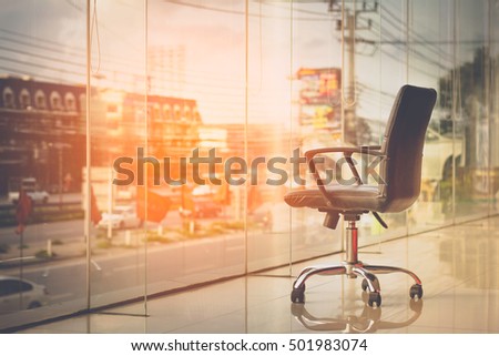 modern black chair in empty office space with large window, vintage picture style process,copy space.