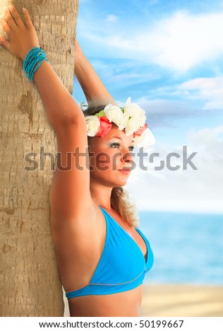 Woman is posing near the trunk at the beach