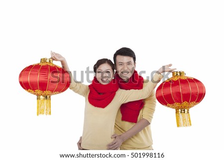 	Portrait of young couple holding red lanterns,paying New Year call 	