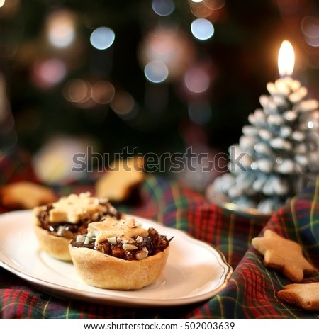 Christmas pastry filled with apples, almonds and chocolate with star shaped cookies. Selective focus and festive background.