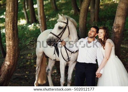 The happinest brides hold hands  in the forest
