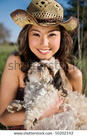 A portrait of a beautiful asian girl with her dog outdoor