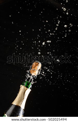 Closeup of champagne explosion. Vertical image on black background