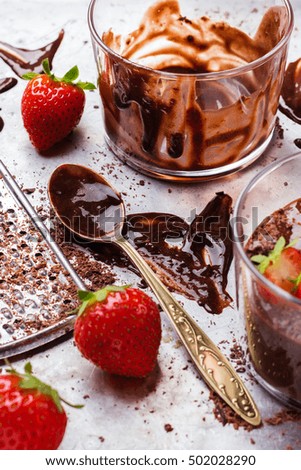 Chocolate mousse with strawberries in glass on rustic table