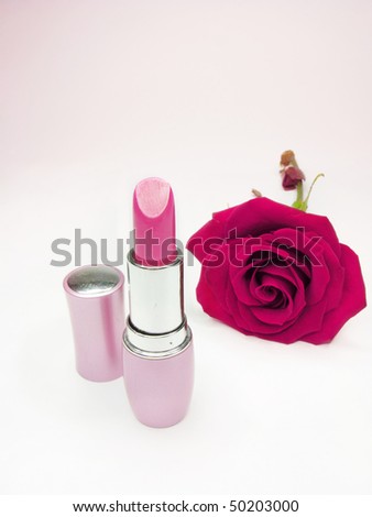 pink lipstick in gold box with damask rose on background
