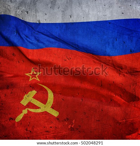 the flag of the Russian Federation and the USSR on the background of a concrete wall