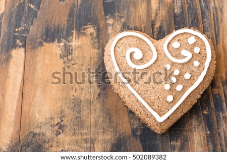 Gingerbread Cookie Heart on a Rustic Wooden Background.