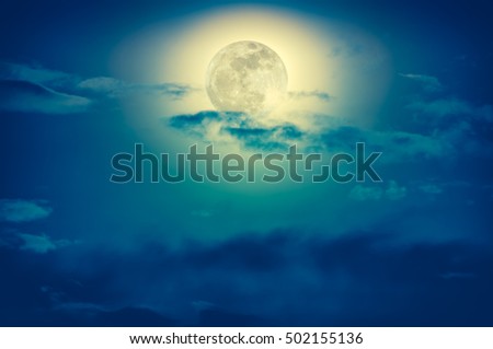 Background of nighttime sky with cloud and full moon with shiny. Natural beauty at night with beautiful moon behind cloud. Cross process and vintage effect tone. 