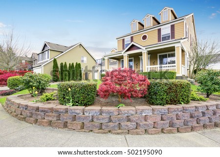 American house exterior with covered porch and columns. Beautiful curb appeal and perfect landscape design. Northwest, USA Royalty-Free Stock Photo #502195090