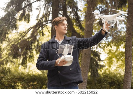 Man running drone with camera . Review of new unmanned aerial quadrocopter outdoor. Modern tool for overhead photo and video