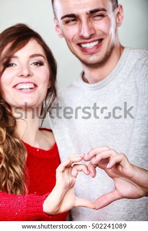 Love concept. Closeup Smiling woman and man forming heart shape with their fingers hands
