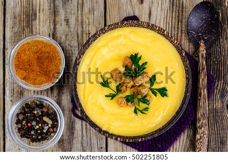 Pumpkin Diet cream soup with croutons in a wooden plate. Studio Photo