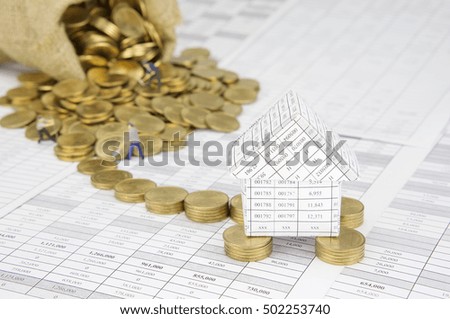 Close up house on pile of gold coins on finance account have blur gold coins overflow from brown sack with construction worker as background. Business finance concepts rich and successful photography.
