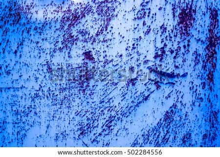 blue black metal plate with cracked paint and big paint spots because of time as background, metal wall with rusty spots and cracked paint as texture, toned to color, high quality resolution