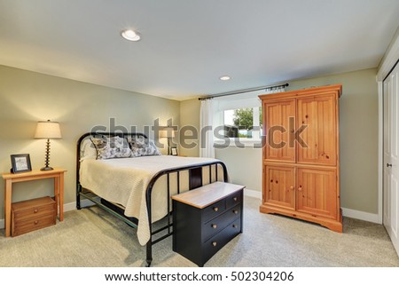 Beige tone bedroom interior with black iron bed and cabinet. Northwest, USA