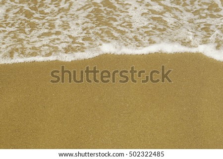 Gentle bubbles wave on the fine yellow sand
