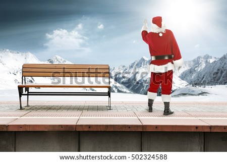 Old santa claus on train station and winter landscape 