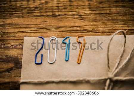 Christmas background. Happy new year 2017 - clips on paper envelope with rope lie on wooden table 