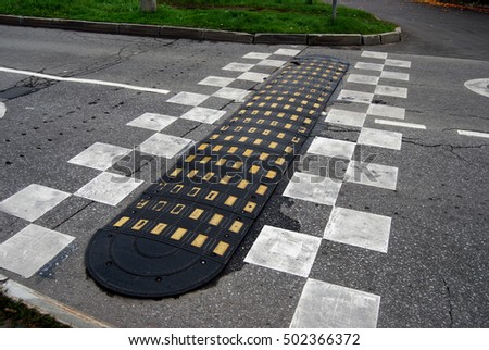 Asphalt road with rubber speed bump and road markings
