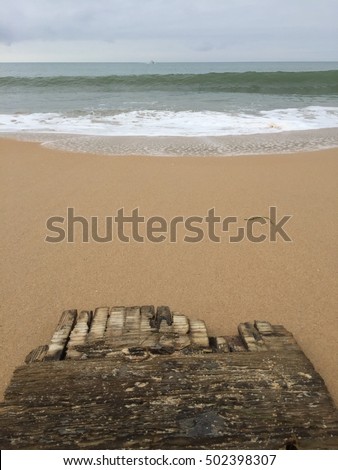 Old weathered wooden board on sandy beach outdoors background