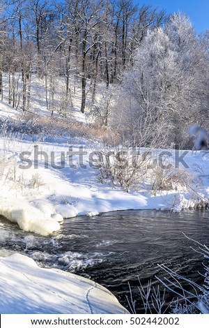 Winter sunny landscape with river and forest.