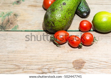 Fresh green avocado on a rustic wooden table