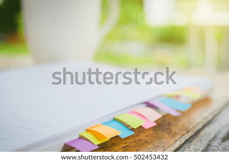 blank note book with colorfull post it on wood table