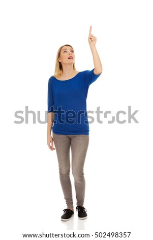Happy young woman pointing up