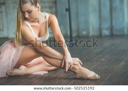 Attractive ballet dancer sitting on floor
