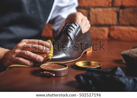 man shining shoes with a rag Royalty-Free Stock Photo #502527196
