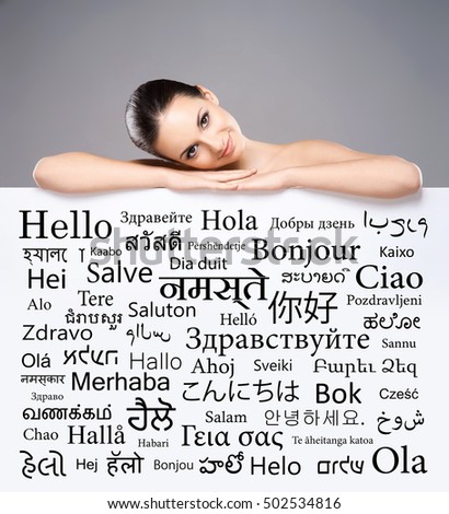 Beautiful girl with a banner of world's different languages over grey background.
