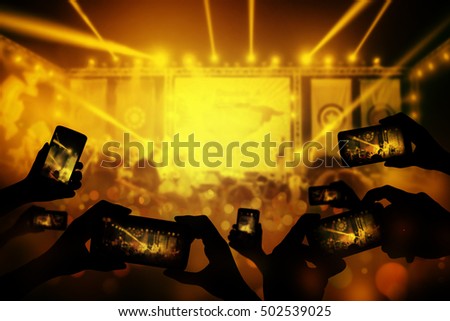 Silhouette of hands using smart phone to take pictures and videos at live concert, smartphone records live music, Take photo in front concert stage, happy youth, luxury party. streaming video.