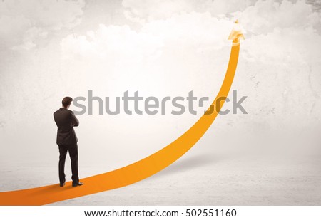 A young adult salesman standing on a big orange arrow pointing up in a bright empty space concept