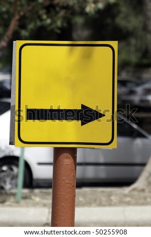 Yellow sign with a black arrow