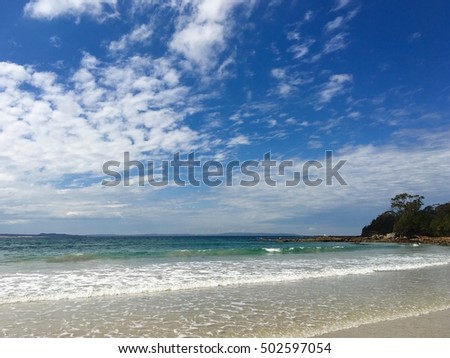 Beautiful empty sand beach with good waves on a nice sunny day, clouds in the sky