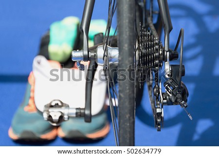 Triathlon bike the transition zone,detail detail bicycle derailleur.In the background running shoes
