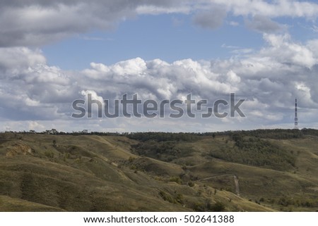 autumn landscape with yellow grass and blue cloudy sky