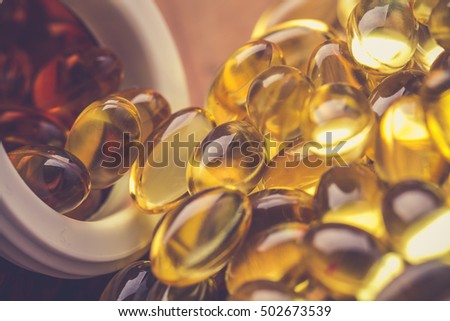 Cod liver oil omega 3 gel capsules isolated on wooden background. Vitamin D capsuls. dietary supplement