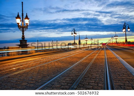 Tram lines on the Pont de Pierre bridge at sunset in Bordeaux, France