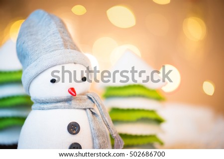 Detail of cute festive snowman with Christmas lights in background