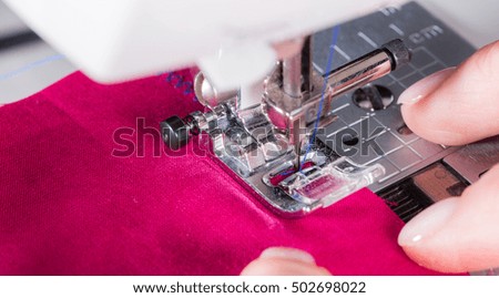 A woman sews on the sewing machine
