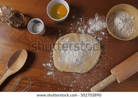 Dough and ingredients on wooden table background. Top view. Rustic style
