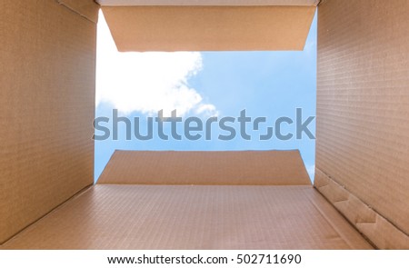 "Thinking Outside the Box" for Create New Ideas and Innovation concept. Inside a cardboard with clear sky and cloud for Background