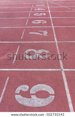 White Number athletic track number on red rubber racetrack, texture of running racetracks in stadium