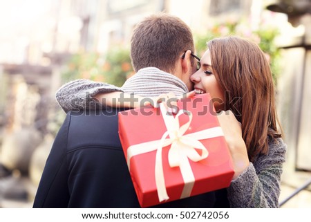 Picture of woman with present giving hug to her man