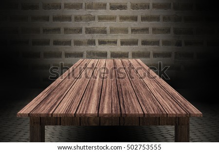 wooden table in front of brick wall 