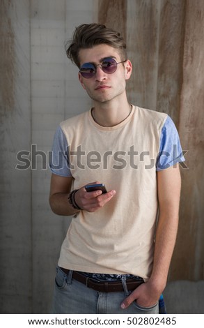 Teenage skater boy using smartphone wifi connected. Teenager portrait on grunge background